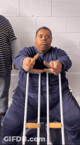 A Man With Crutches Is Holding A French Fry GIF