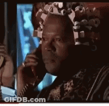 A Man With Curlers In His Hair Is Talking On A Phone GIF