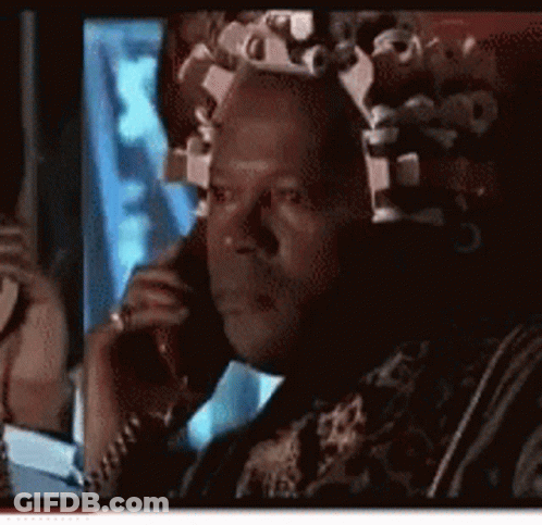 A Man With Curlers In His Hair Is Talking On A Phone GIF