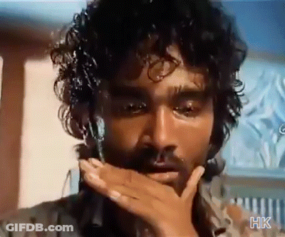 A Man With Curly Hair And A Beard Covering His Mouth With His Hand .. GIF
