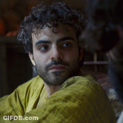 A Man With Curly Hair And A Beard In A Yellow Shirt GIF