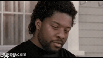 A Man With Curly Hair And A Beard Is Looking At The Camera . GIF