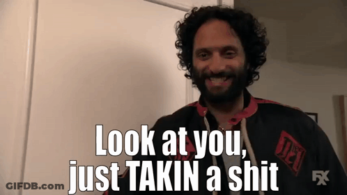 A Man With Curly Hair And A Beard Is Smiling And Saying Look At You Just Takin A Shit GIF