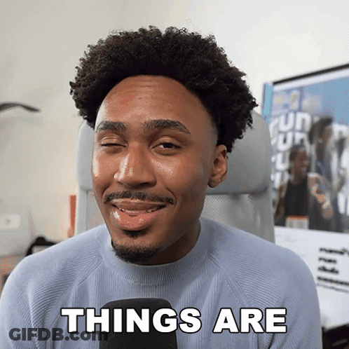 A Man With Curly Hair And A Beard Is Smiling And Says Things Are GIF