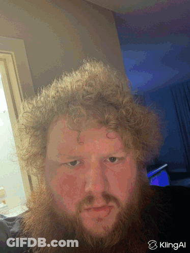 A Man With Curly Hair And A Beard Is Taking A Selfie With Klingai In The Corner GIF
