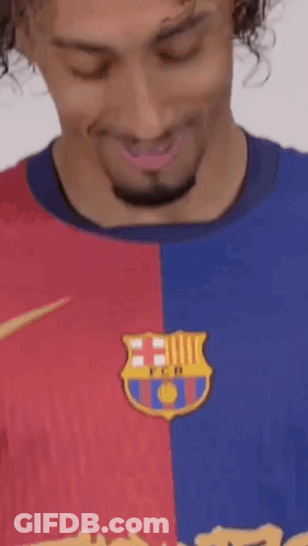 A Man With Curly Hair And A Beard Is Wearing A Barcelona Shirt . GIF