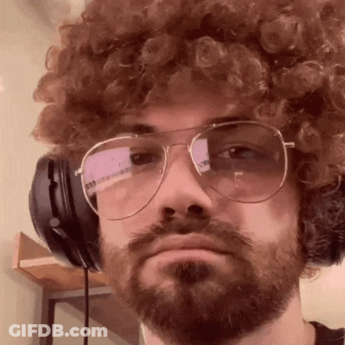 A Man With Curly Hair And A Beard Wearing Headphones And Glasses GIF