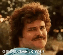 A Man With Curly Hair And A Mustache Is Giving A Thank You Gesture . GIF
