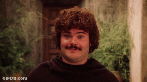 A Man With Curly Hair And A Mustache Is Making A Face GIF