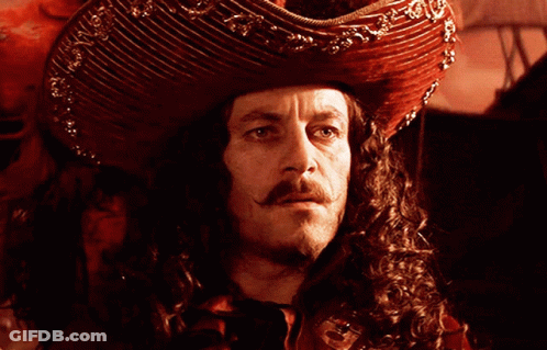 A Man With Curly Hair And A Mustache Is Wearing A Red Hat GIF