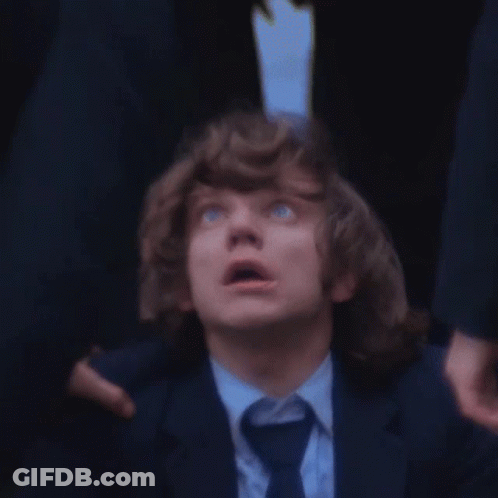 A Man With Curly Hair And Blue Eyes Looks Up At Something GIF