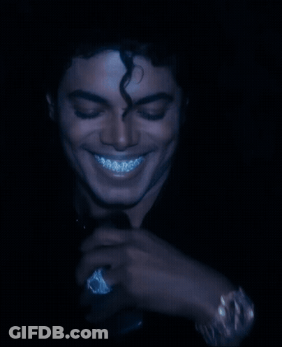 A Man With Curly Hair And Braces On His Teeth Is Smiling GIF