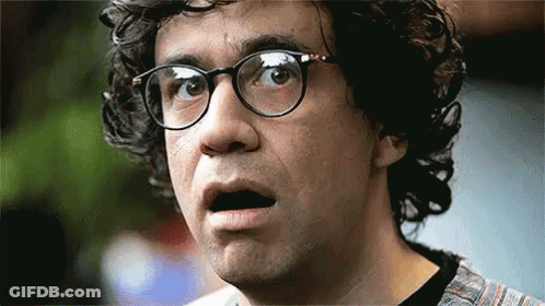 A Man With Curly Hair And Glasses Is Making A Funny Face . GIF