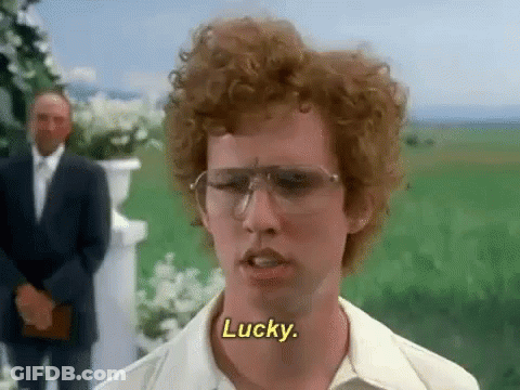 A Man With Curly Hair And Glasses Says Lucky In A Field GIF
