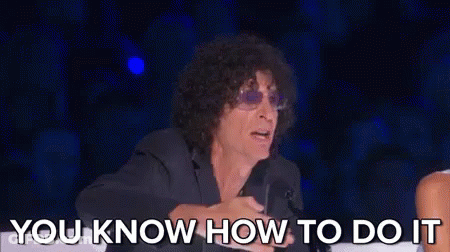 A Man With Curly Hair And Sunglasses Is Sitting In A Chair Talking To A Woman . GIF