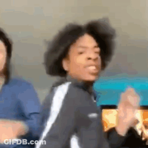 A Man With Curly Hair Is Dancing In A Blurry Photo While A Woman Looks On . GIF