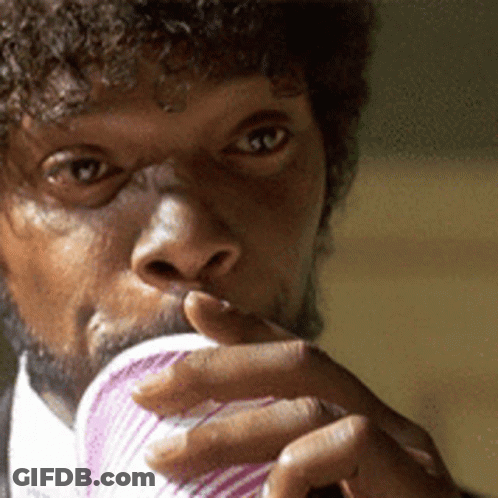 A Man With Curly Hair Is Drinking From A Pink Cup GIF