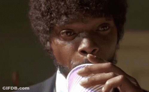 A Man With Curly Hair Is Drinking From A Purple Cup GIF
