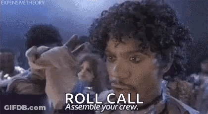 A Man With Curly Hair Is Holding A Piece Of Paper And Says `` Roll Call Assemble Your Crew . '' GIF