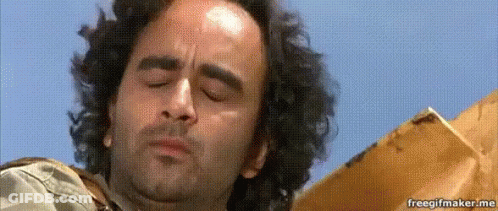 A Man With Curly Hair Is Looking Down With His Eyes Closed And His Mouth Open . GIF