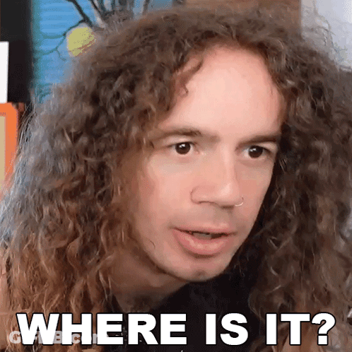 A Man With Curly Hair Is Making A Face And Asking Where Is It GIF