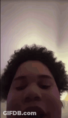 A Man With Curly Hair Is Making A Funny Face GIF