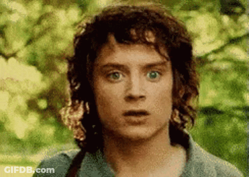A Man With Curly Hair Is Making A Surprised Face . GIF