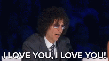 A Man With Curly Hair Is Sitting In Front Of A Microphone And Saying `` I Love You , I Love You '' GIF