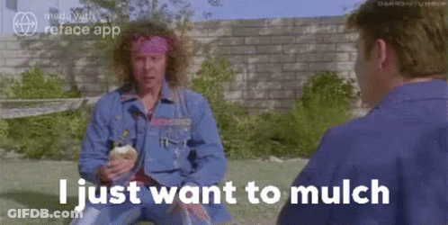A Man With Curly Hair Is Sitting In The Grass Talking To Another Man While Holding An Ice Cream Cone . GIF