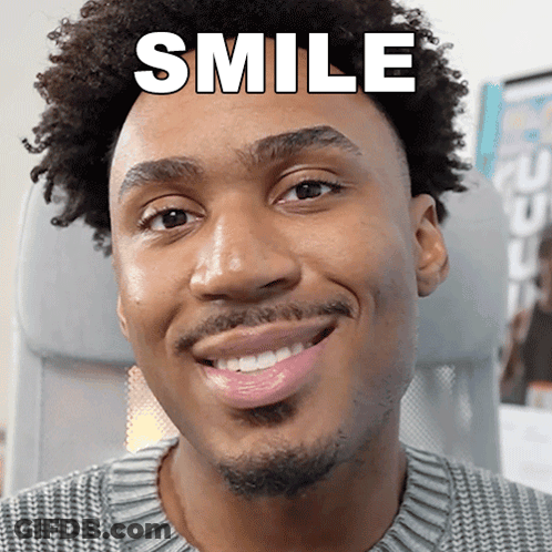 A Man With Curly Hair Is Smiling With The Word Smile Above His Head GIF