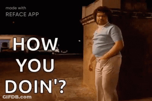 A Man With Curly Hair Is Standing In Front Of A Building . GIF