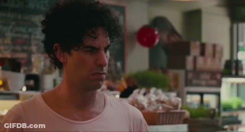 Man With Curly Hair Standing At Store Counter GIF