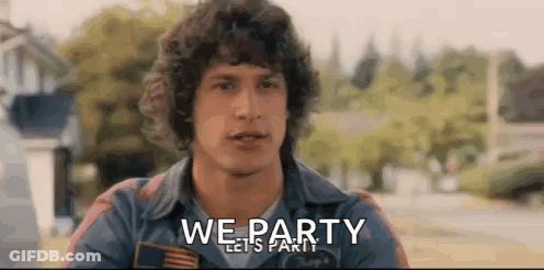 A Man With Curly Hair Is Standing In Front Of A Sign That Says `` We Party Lets Party '' . GIF