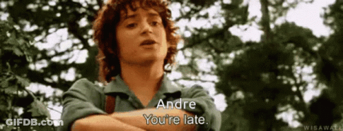 A Man With Curly Hair Is Standing In Front Of Trees And Says Andre You 'Re Late . GIF