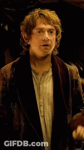 A Man With Curly Hair Is Wearing A Brown Jacket GIF