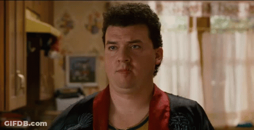 A Man With Curly Hair Is Wearing A Robe And Looking At The Camera GIF