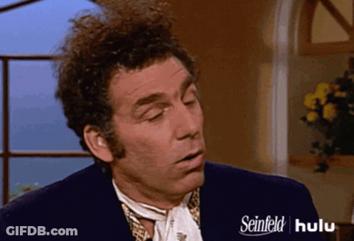 A Man With Curly Hair Is Wearing A Seinfeld Advertisement GIF