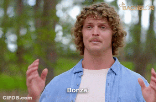 Man With Curly Hair Saying Bonza In Front Of Bachelor Logo GIF