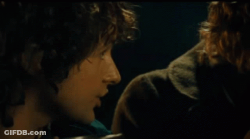 A Man With Curly Hair Says " I 'M Sharing It " In A Dark Room GIF