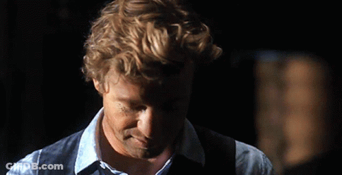 A Man With Curly Hair Wearing A Blue Shirt And Vest GIF