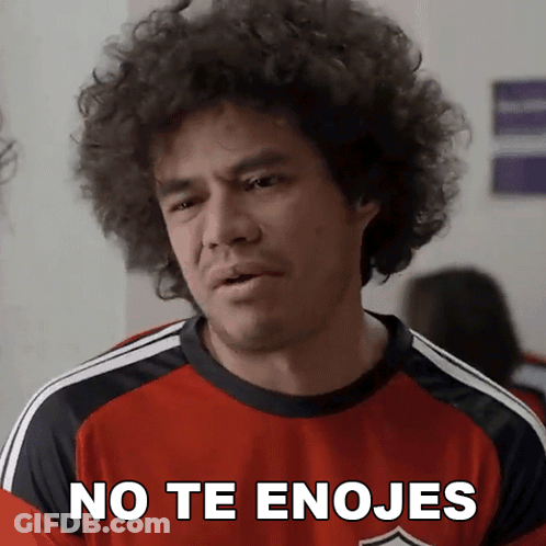 A Man With Curly Hair Wearing A Red Shirt That Says " No Te Enojes " GIF