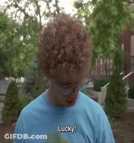 A Man With Curly Hair Wearing Glasses And A Blue Shirt Says Lucky GIF