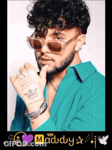 A Man With Curly Hair Wearing Sunglasses And A Purple Heart With The Word Maddy On It GIF