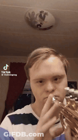 A Man With Down Syndrome Is Playing A Trumpet In A Tiktok GIF