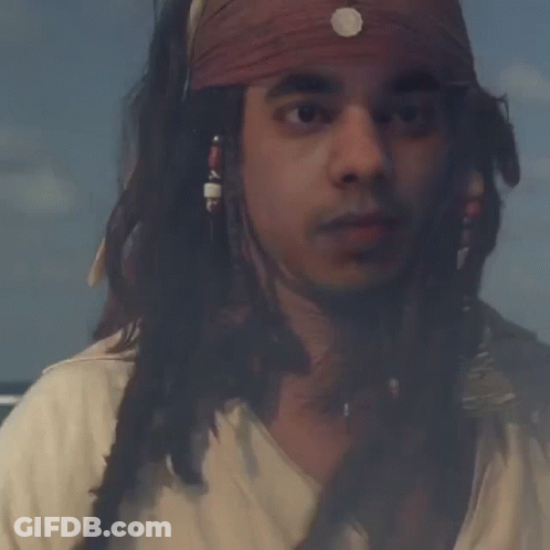 Man With Dreadlocks And Bandana Looking At Camera GIF