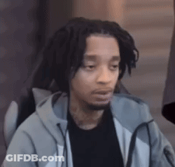 A Man With Dreadlocks And A Beard Is Sitting In A Chair With His Eyes Closed . GIF