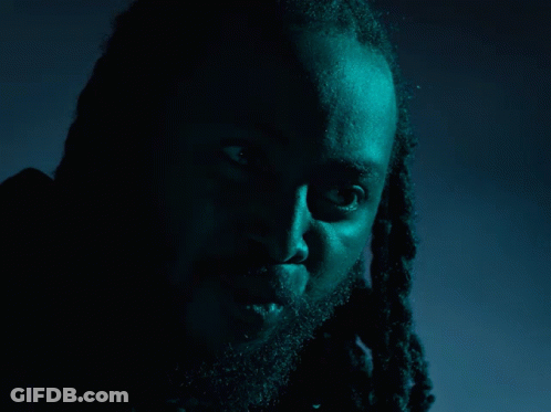 A Man With Dreadlocks And A Beard Says What In Yellow GIF