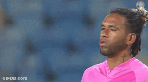 A Man With Dreadlocks And A Cross Tattoo On His Neck Is Wearing A Pink Shirt GIF