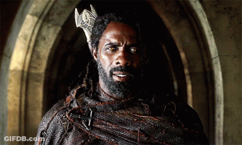 Man With Dreadlocks And Crown In Dark Room GIF