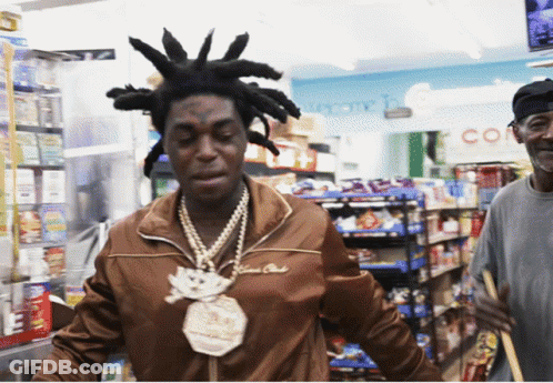 A Man With Dreadlocks And A Necklace That Says $ 100,000 On It GIF